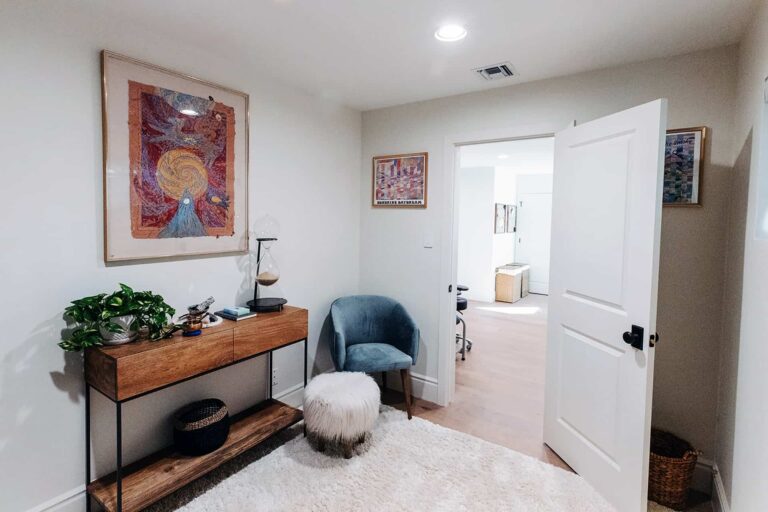 Therapy room with spiritual artwork, plants, and modern decor.