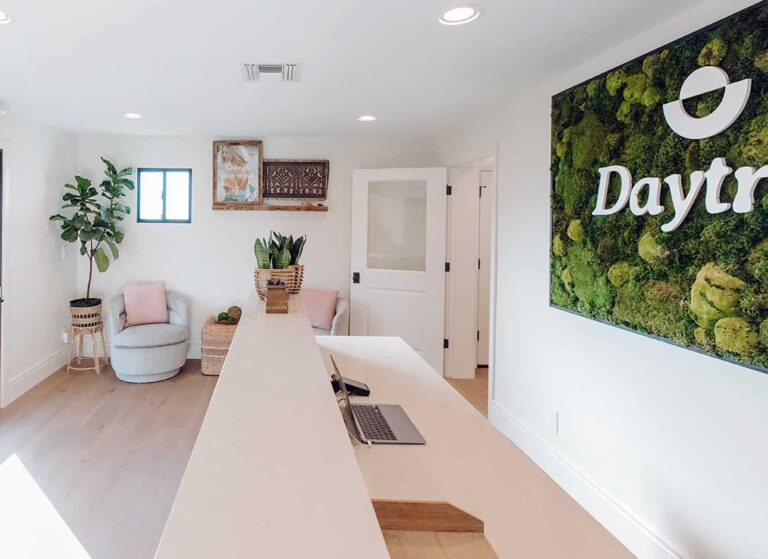 Reception area at Daytryp featuring a natural moss wall with the Daytryp logo.